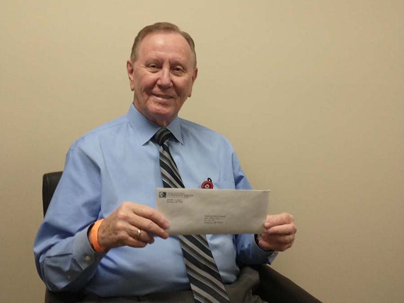 Good Shepherd Community Health Foundation director presents a check for a two unit shower trailer